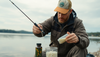 A fisherman mixing secret bait formula by a lakeside